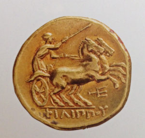 In ancient times, coins acted as the first mass media of this period. Several coins exist, where images of rulers, locations and historic events (e.g. wars, battles, sport events, etc.) were portraied and as such educated people. The coin in the enclosed picture is a good example as it was produced in a royal coin shop in Macedon, Pella and Amphipolis. The gold stater coin was produced between 322–315 B.C. and shows Alexander the Great. It was minted shortly after his death and for many symbolized his achievements for the Hellenistic society.